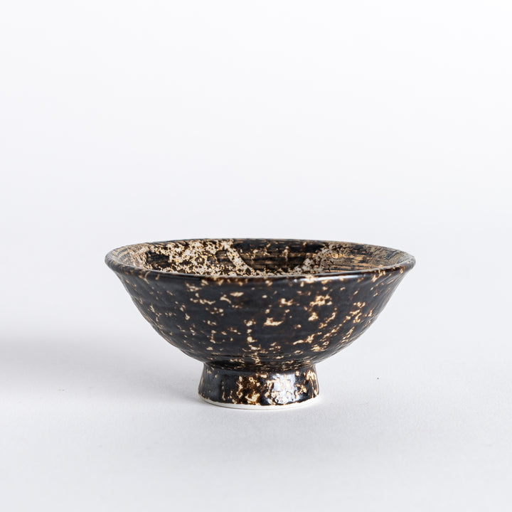 Side view of the sake cup, highlighting the smooth curved body and unique rustic finish.