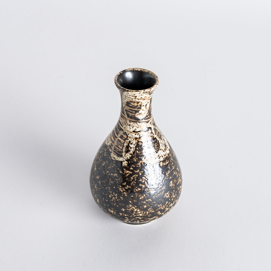 Slightly angled view of the sake flask, highlighting the intricate pattern and rustic finish.