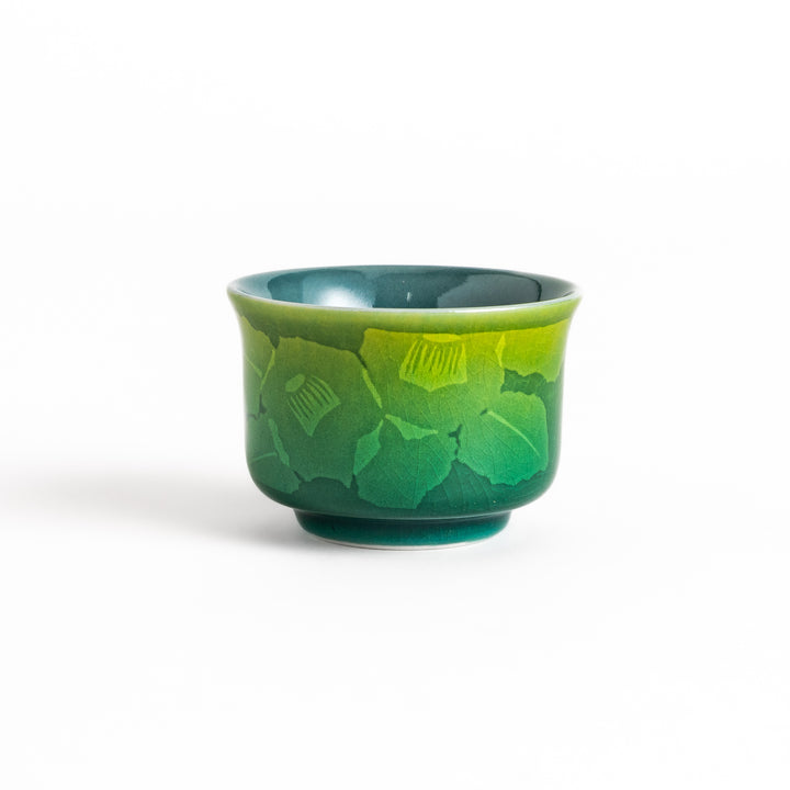 Green ceramic sake cup with a subtle floral pattern and a unique gradient glaze, perfect for enjoying your favorite sake.