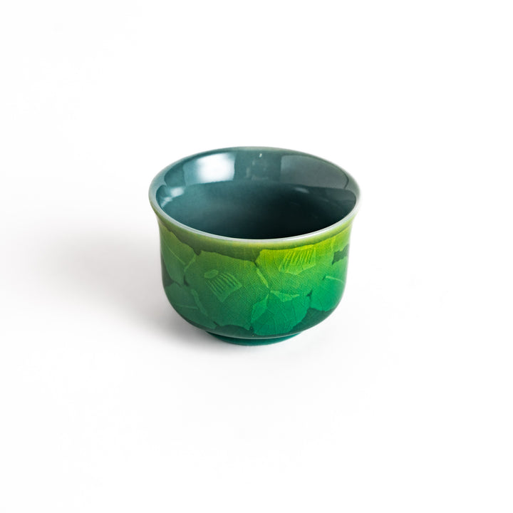 Green ceramic sake cup with a subtle floral pattern and a unique gradient glaze, perfect for enjoying your favorite sake.