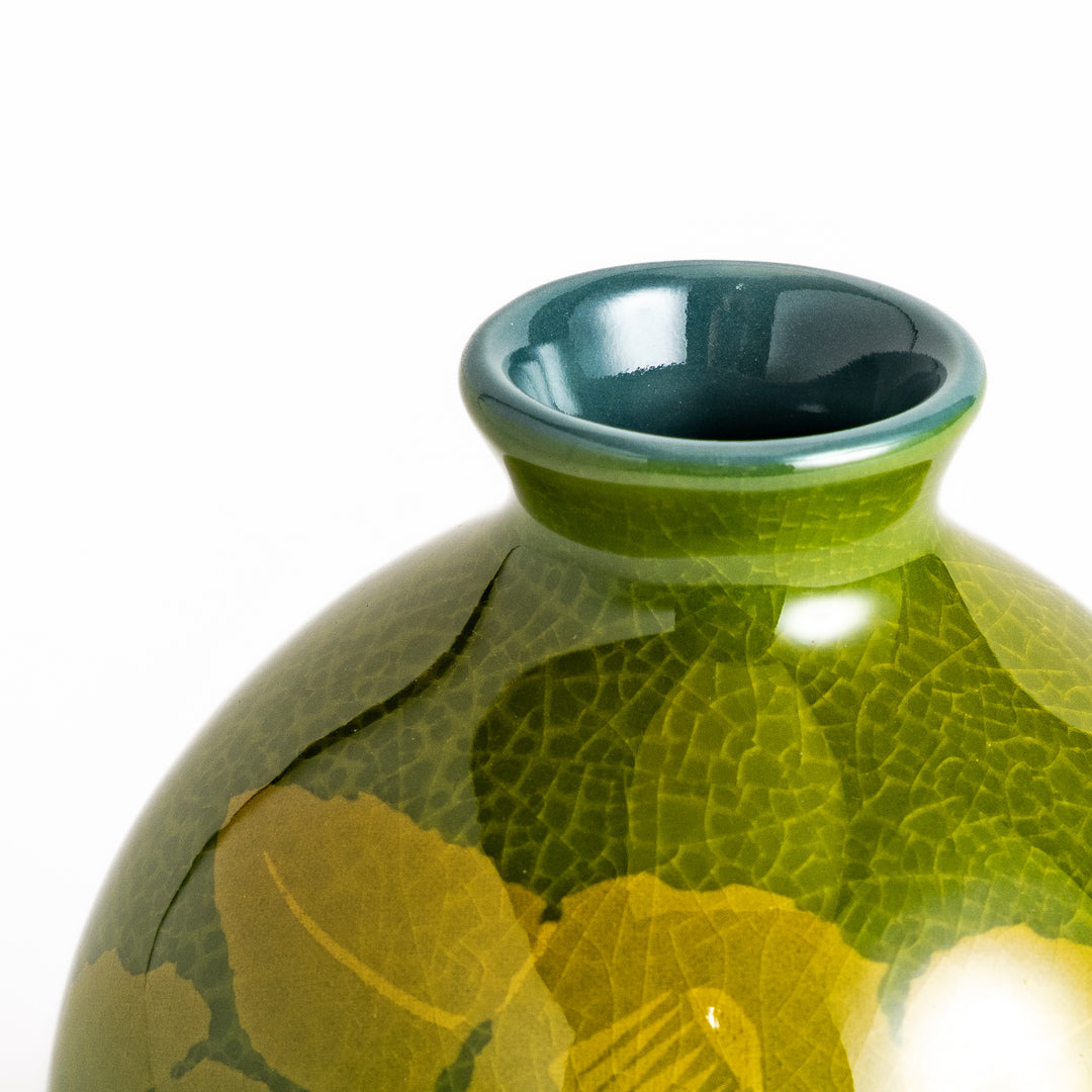 Green ceramic sake carafe with a subtle leaf pattern and a unique crackled glaze, perfect for serving sake in style.