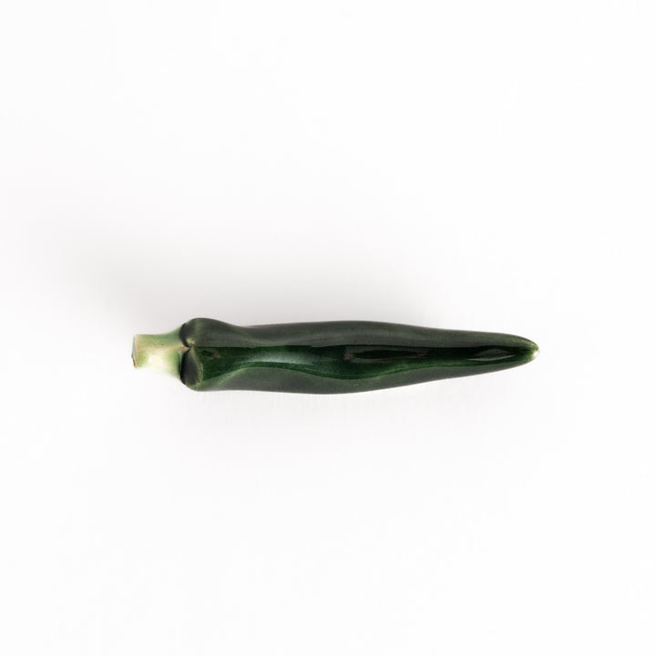 Top view of the green chili pepper chopsticks rest, showcasing its realistic shape and smooth finish.