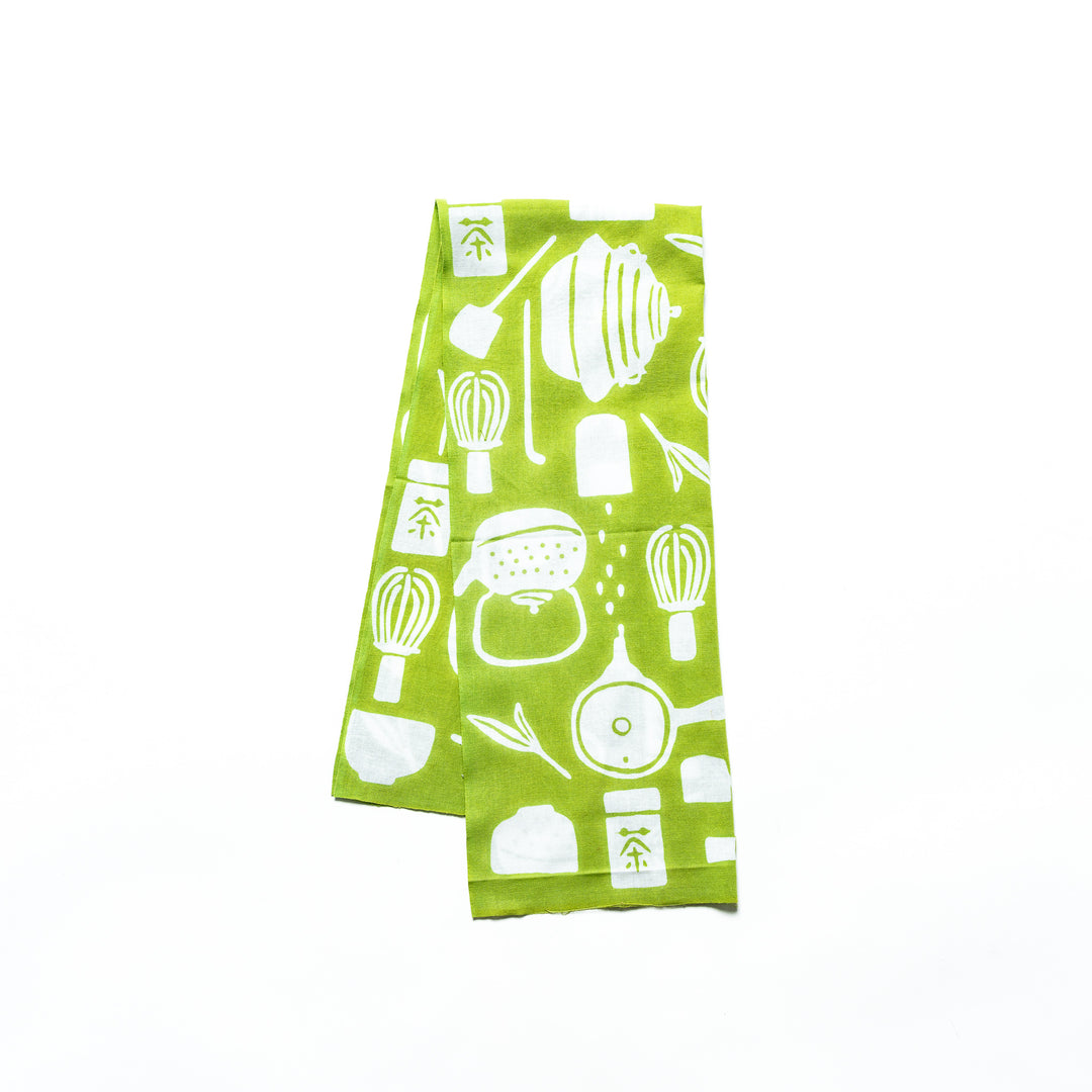 Light green tenugui hand towel with white tea-themed illustrations, folded for display.