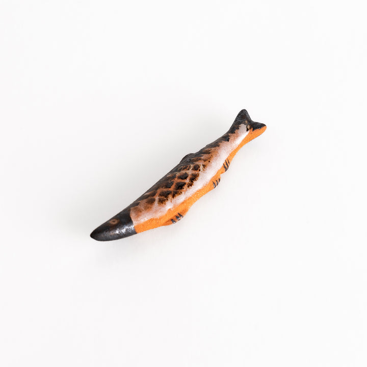 Top view of the saury-shaped chopsticks rest, displaying its detailed fins, scales, and a balanced glaze of black and brown hues.