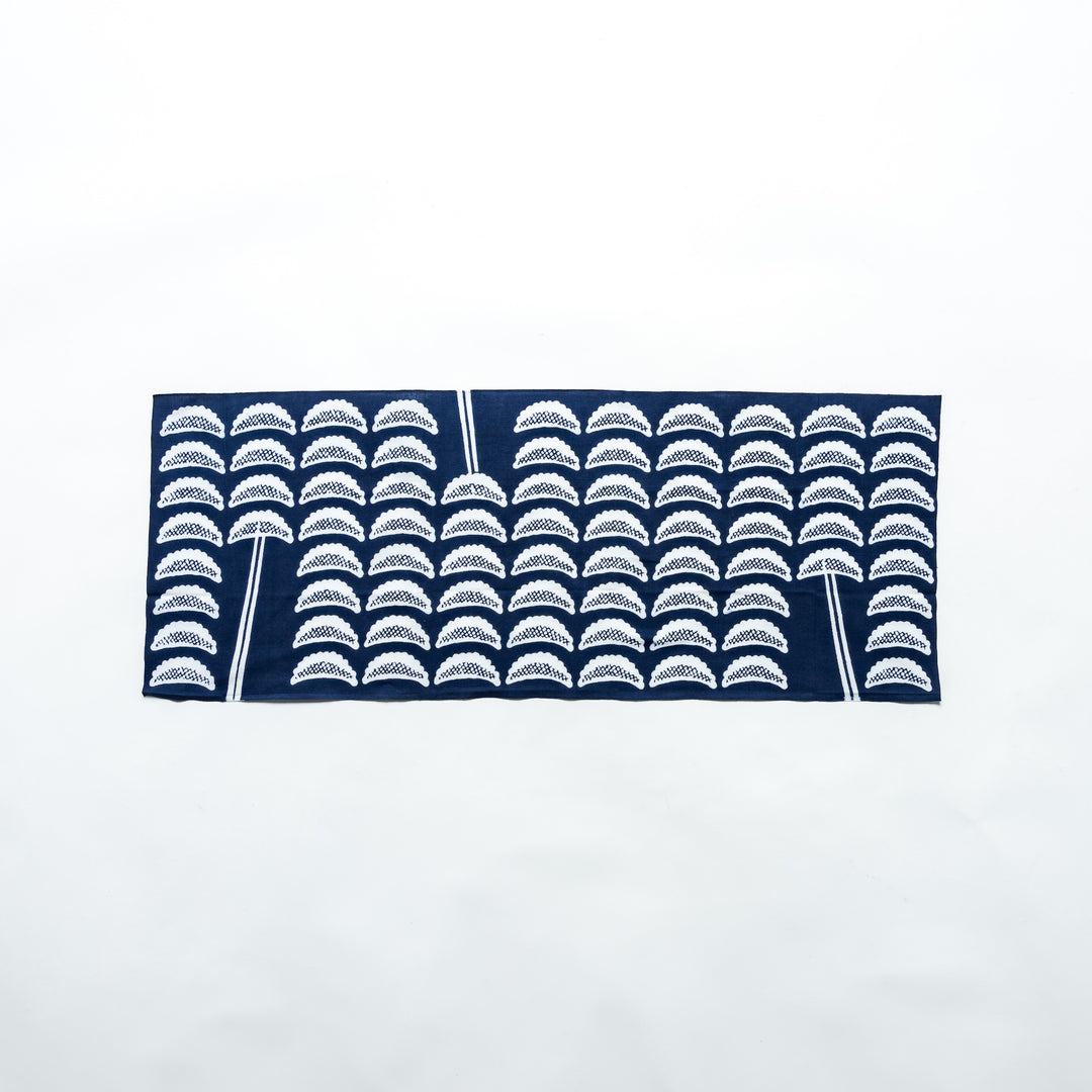 Navy blue tenugui with white gyoza patterns, fully spread out horizontally, showcasing its design clearly against a white background.