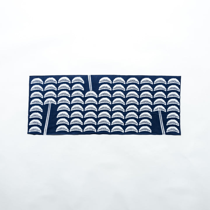 Navy blue tenugui with white gyoza patterns, fully spread out horizontally, showcasing its design clearly against a white background.