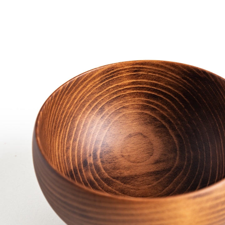 Detailed view of the interior of a dark wooden bowl, showing the gentle curves and polished surface.