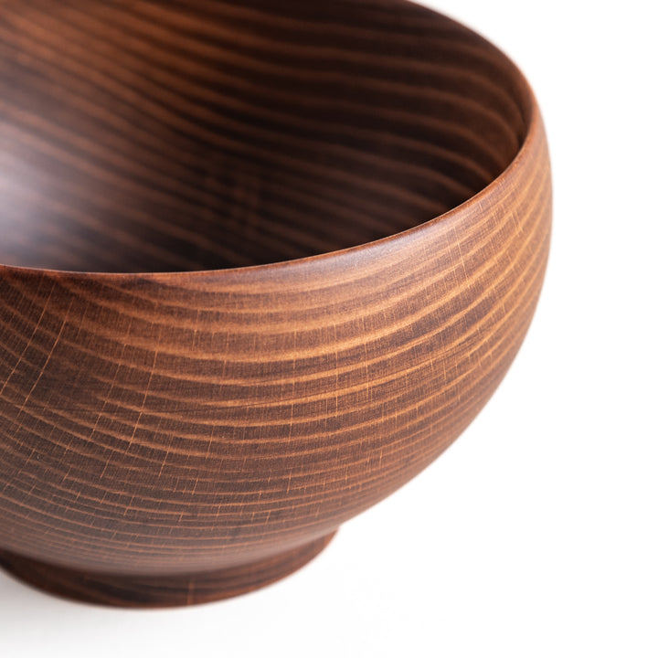 Top-down view of a dark wooden bowl, featuring a smooth rim and engraved markings on the base, adding a unique touch.