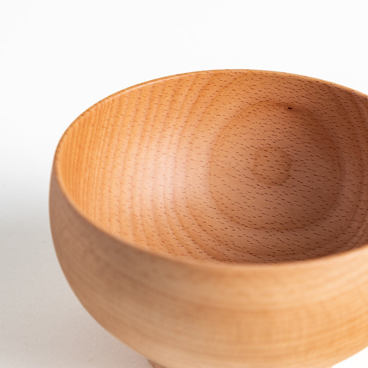 Close-up of the rim of a beech wood bowl, showcasing its polished surface and beautiful wood texture. Ideal for soups.