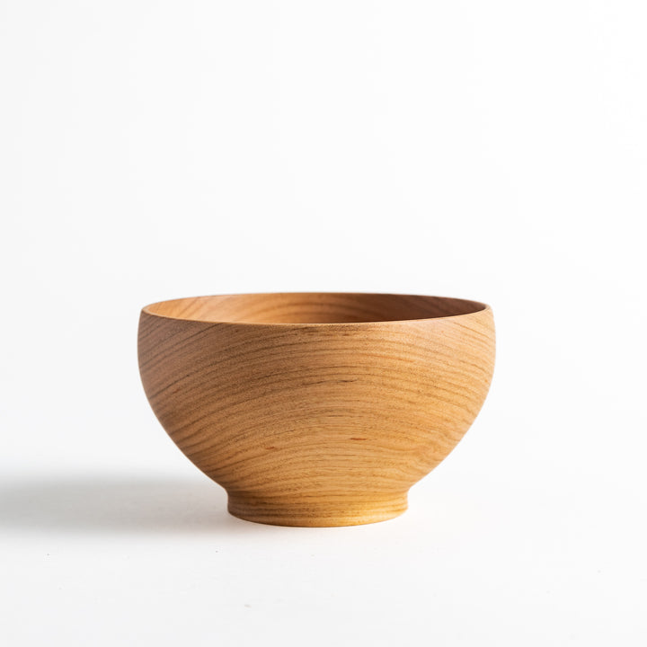 Smooth cherry wood bowl with a natural grain, displayed on a white background. Simple yet elegant design with subtle wood texture.