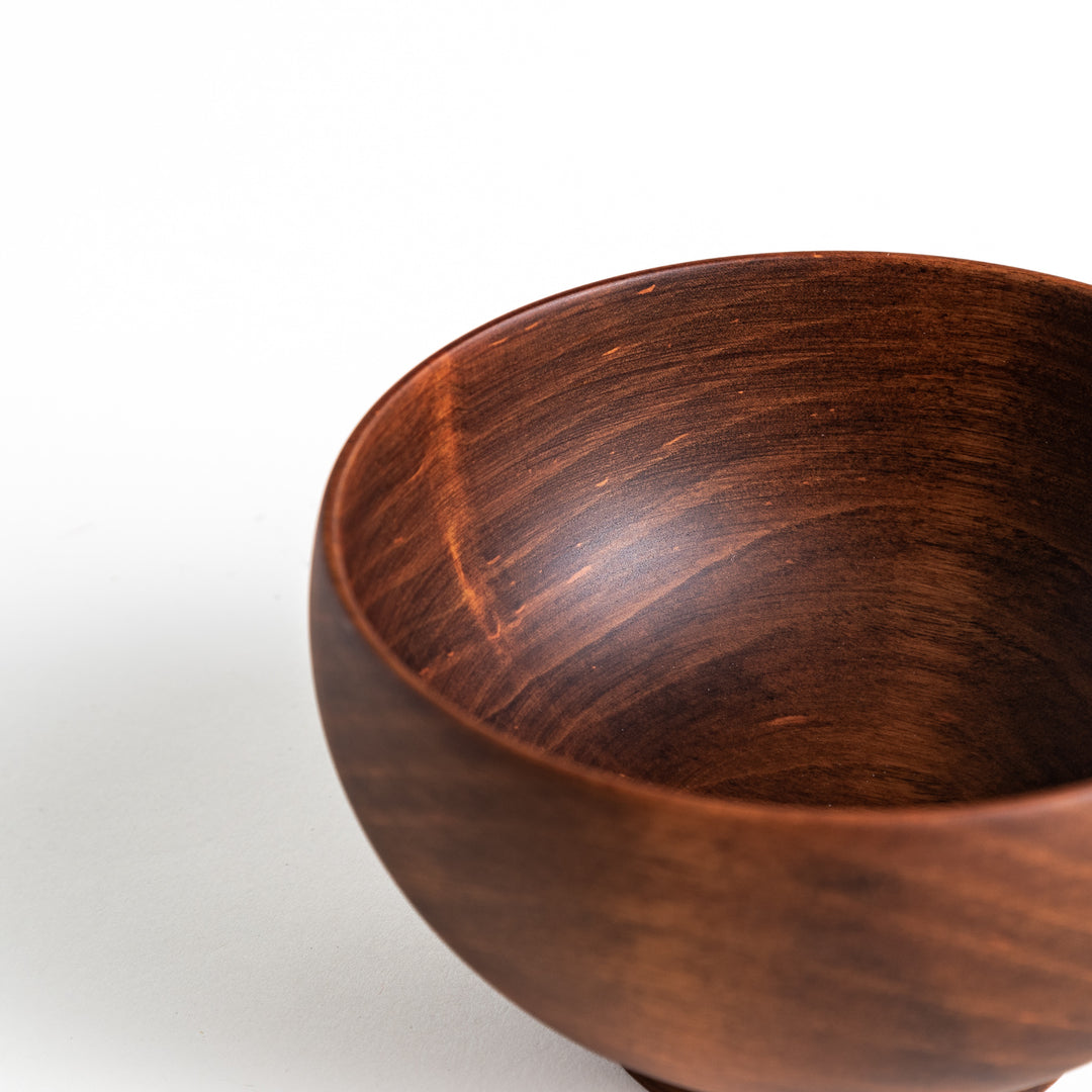 Close-up of the dark brown cherry wood bowl’s rim and inner surface, emphasizing the wood grain.