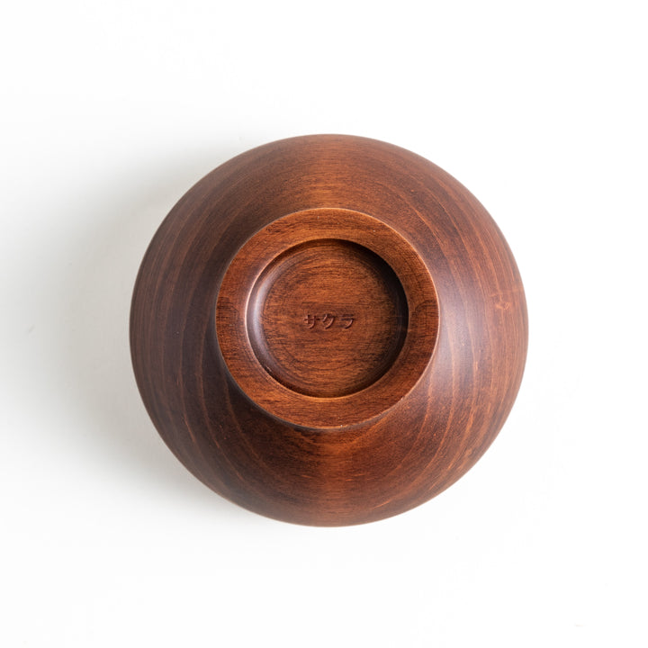 Underside of the dark brown cherry wood bowl with “サクラ” inscribed at the base, highlighting craftsmanship.