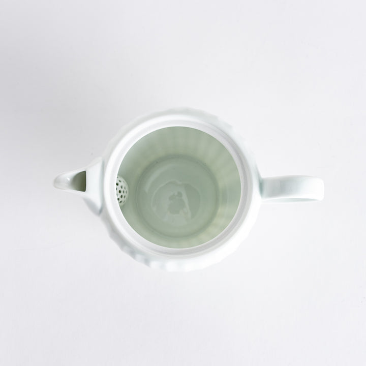 Top view of the white teapot highlighting the decorative lid and smooth surface, ideal for brewing tea.