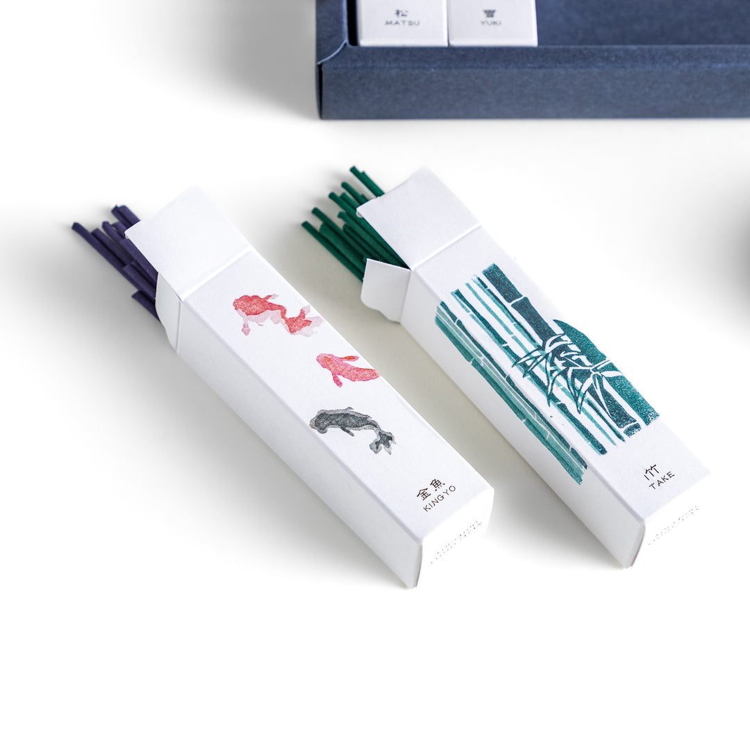 Incense set featuring 10 uniquely designed boxes, each with a different fragrance inspired by nature, along with a ceramic incense holder for an elegant burning experience.