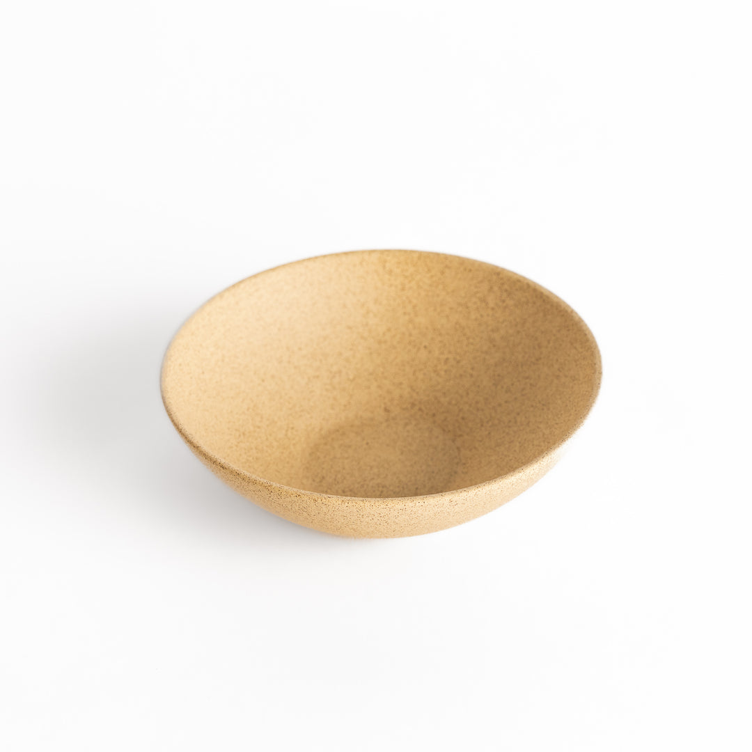 Slightly angled view of a beige teacup emphasizing its smooth surface and elegant form.