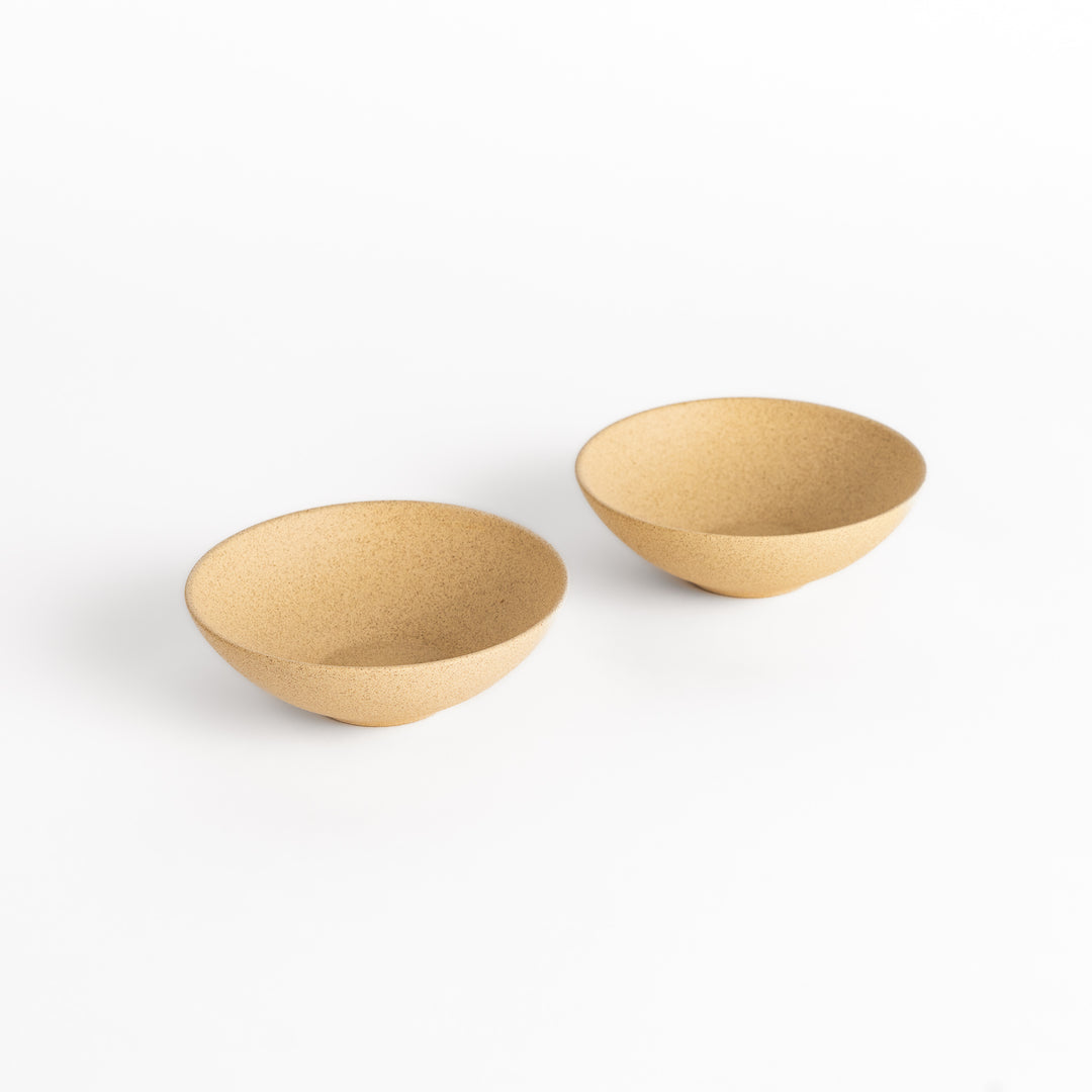 Two beige ceramic teacups with a smooth texture, displayed side by side as a matching set, perfect for tea service.