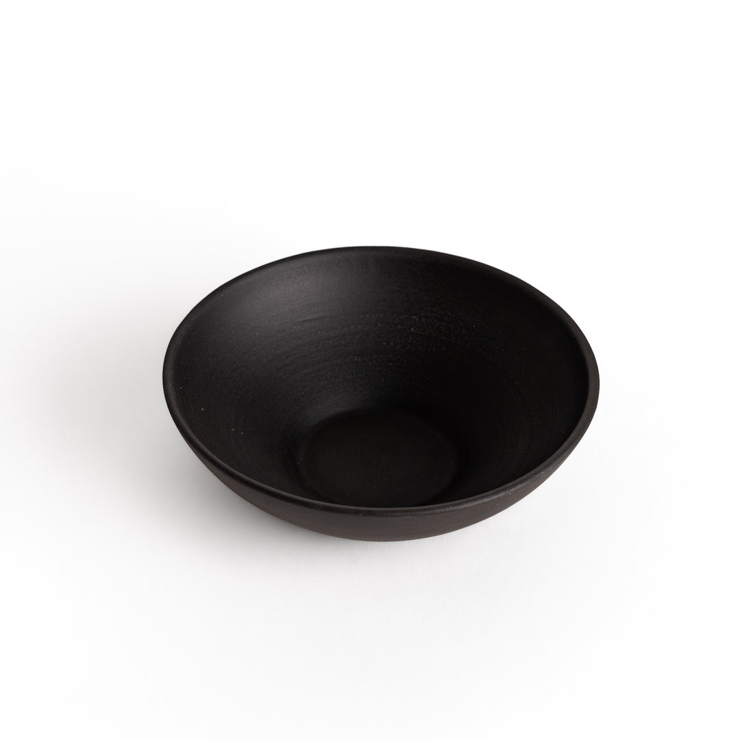 Slightly angled view of a black teacup, emphasizing its modern and understated craftsmanship.