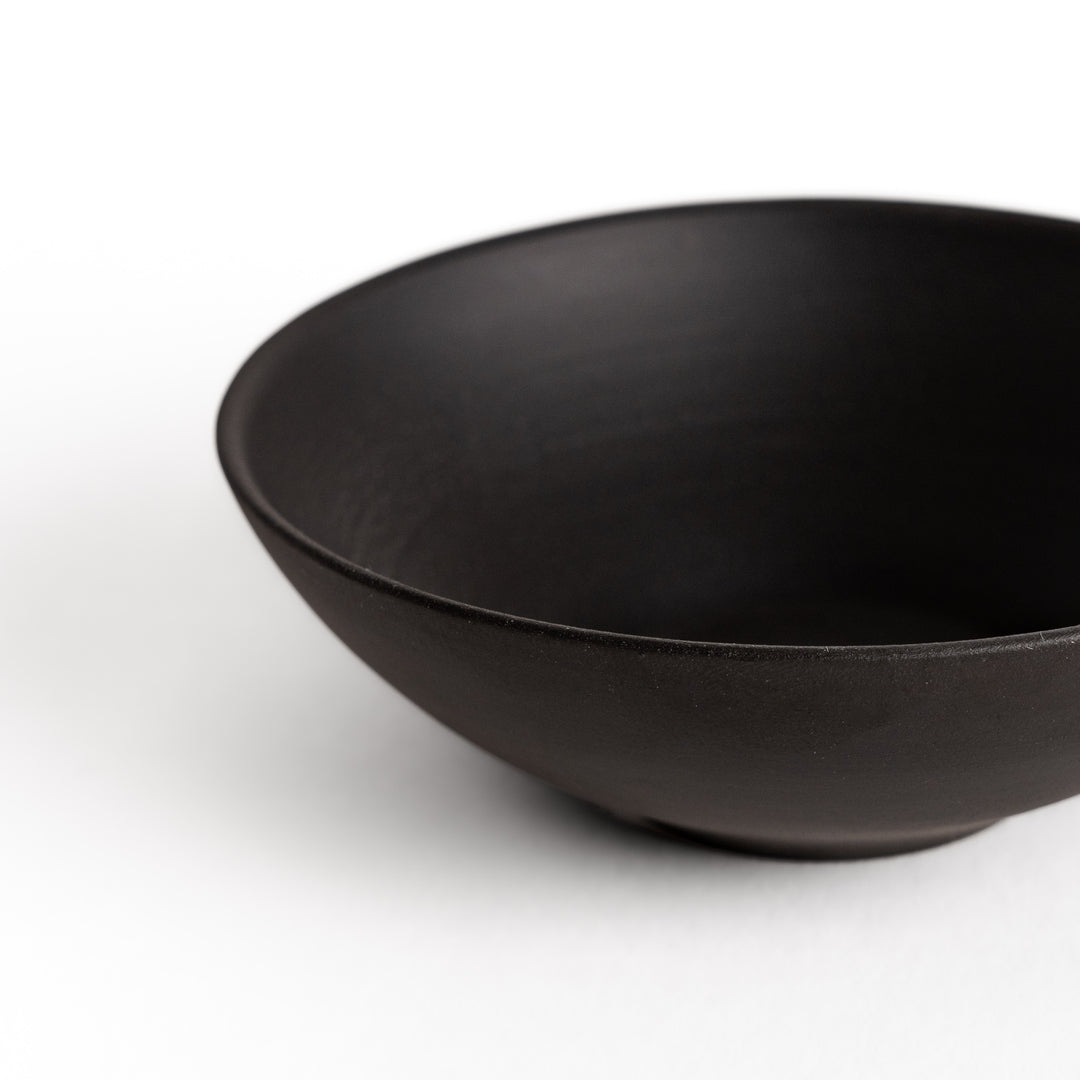 Close-up of a black teacup, focusing on its matte finish and seamless design details.