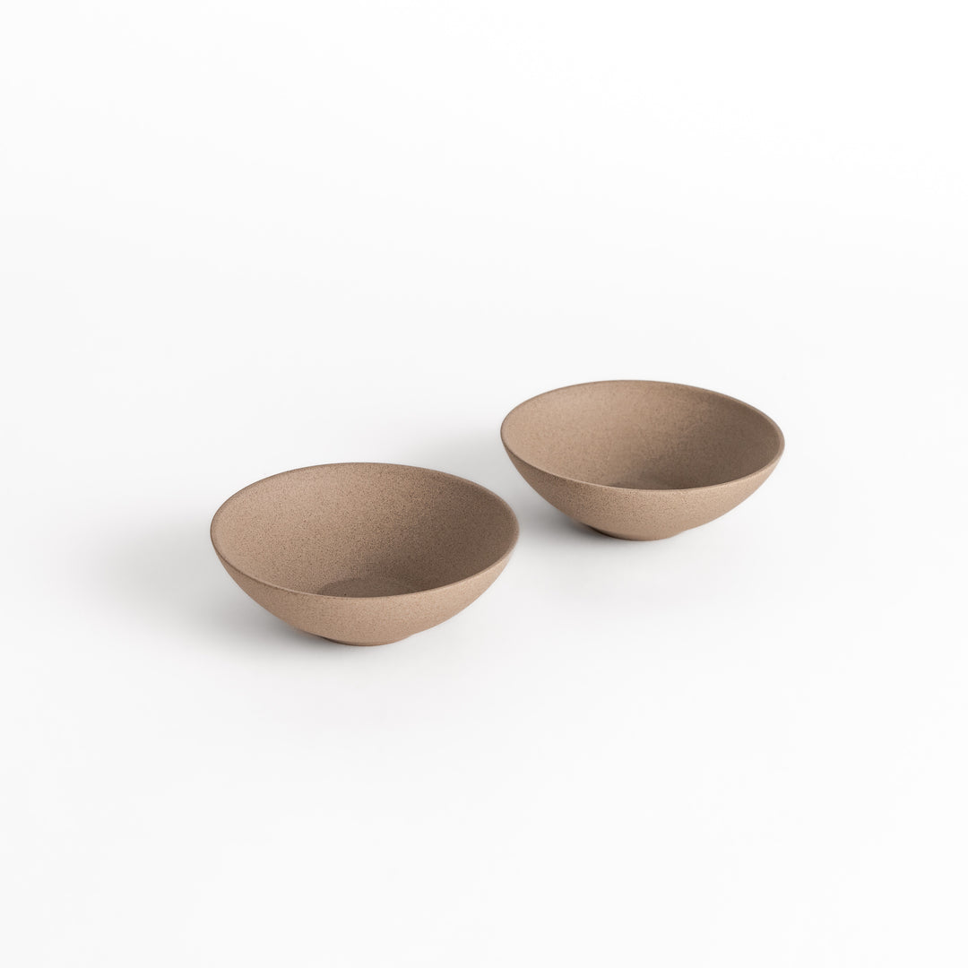 Two minimalist gray teacups with a textured surface, elegantly paired as a set for a harmonious tea experience.