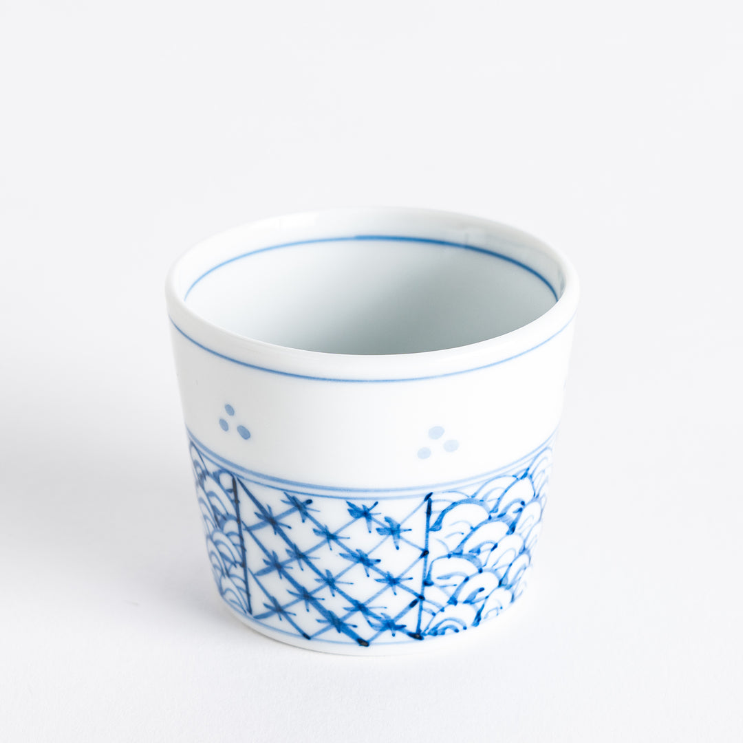 A small white bowl adorned with a delicate blue wave pattern around the edge, perfect for sauces or small sides.