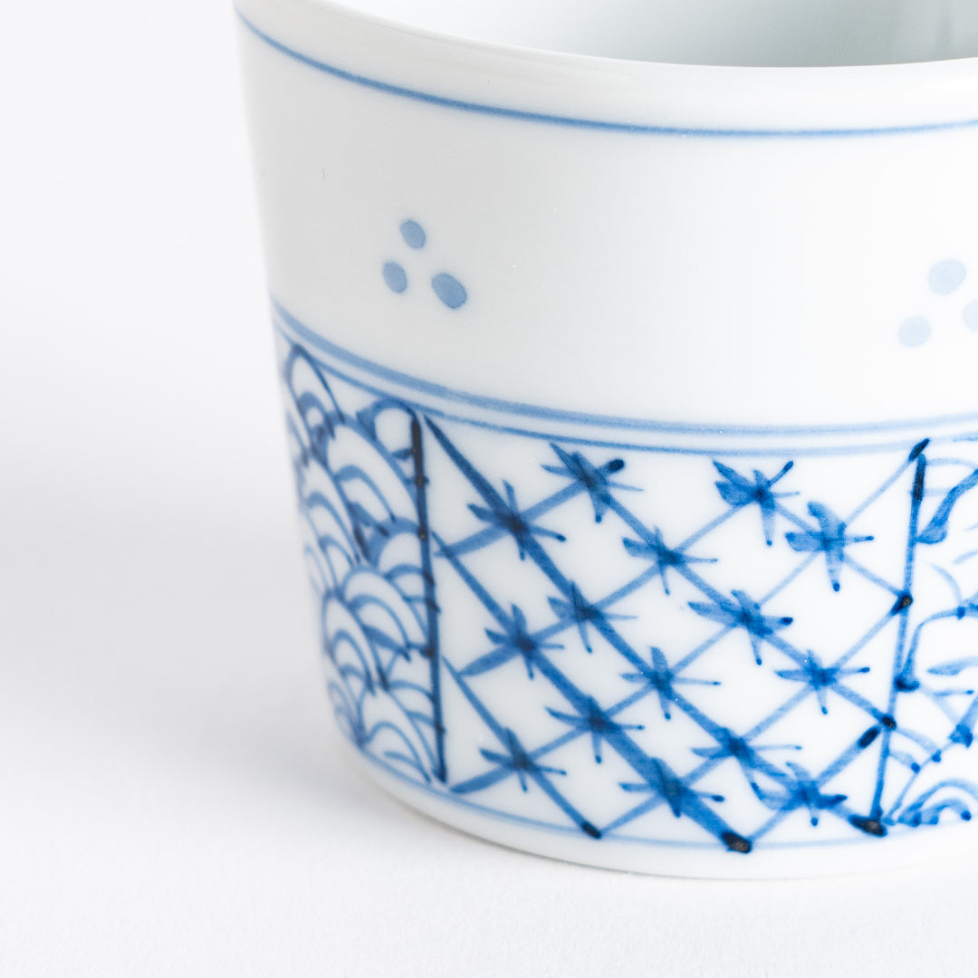 A small white bowl adorned with a delicate blue wave pattern around the edge, perfect for sauces or small sides.