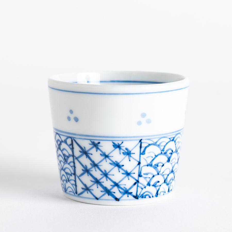 A small white bowl adorned with a delicate blue wave pattern around the edge, perfect for sauces or small sides.