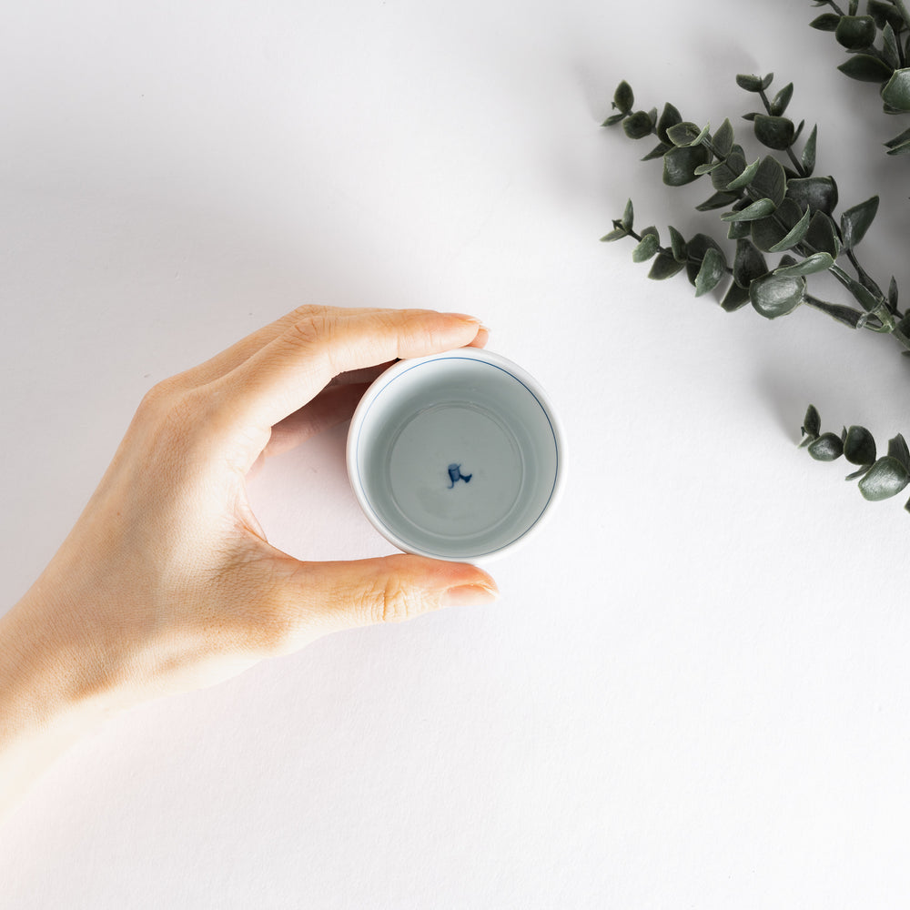 A small white bowl adorned with a delicate blue wave pattern around the edge, perfect for sauces or small sides.