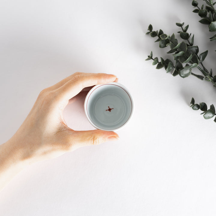 A small white bowl adorned with a delicate blue wave pattern around the edge, perfect for sauces or small sides.