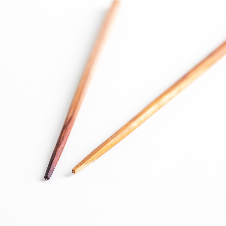 Three pairs of natural zelkova wood chopsticks, each with a different geometric shape—triangle, hexagon, and round.