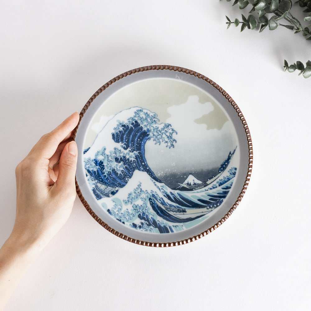 A round salad plate with the famous blue wave design, framed by a textured rim, inspired by Hokusai’s iconic art.