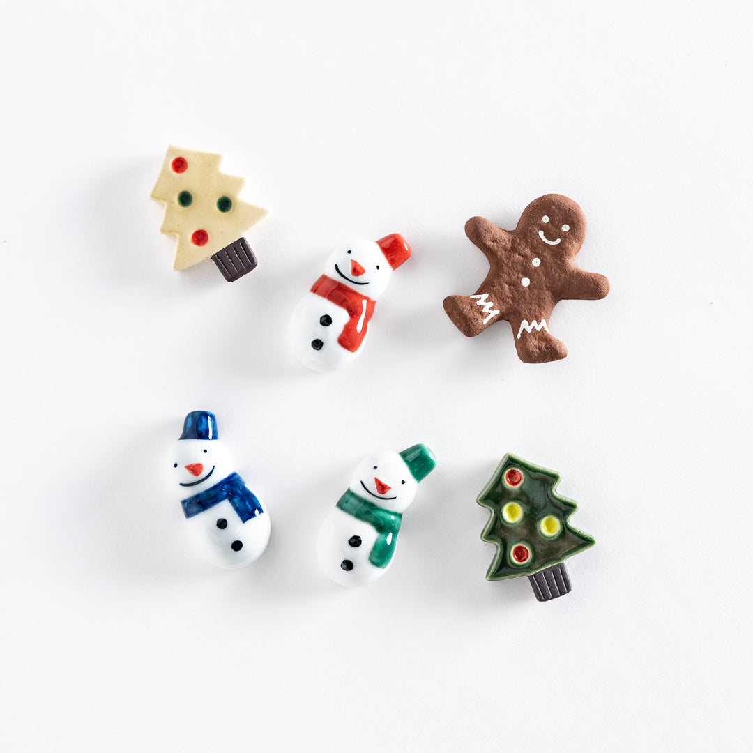 Festive holiday chopstick rests in various shapes, including snowmen with scarves, Christmas trees with ornaments, and a gingerbread cookie.