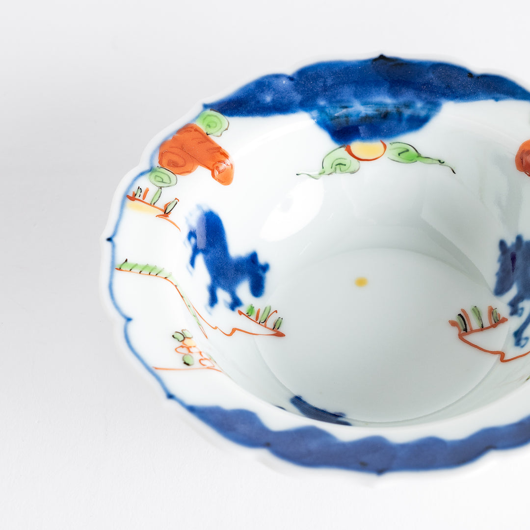 A small dessert bowl featuring colorful designs, including a galloping horse and abstract landscape motifs.