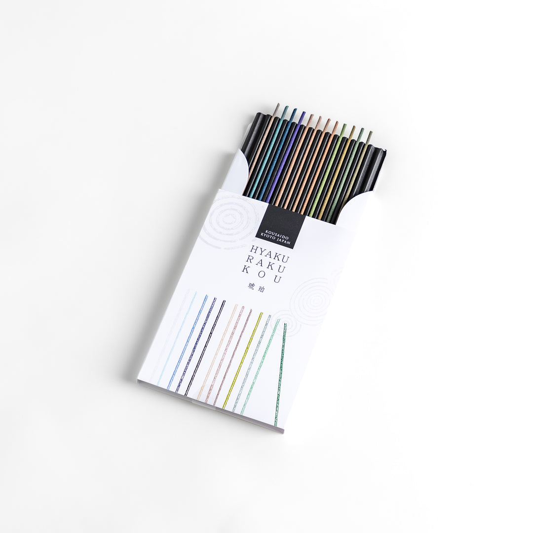 Incense set featuring a variety of colorful sticks elegantly packaged in a sleek white box with subtle circular patterns, offering a refined selection of rich and soothing aromas.