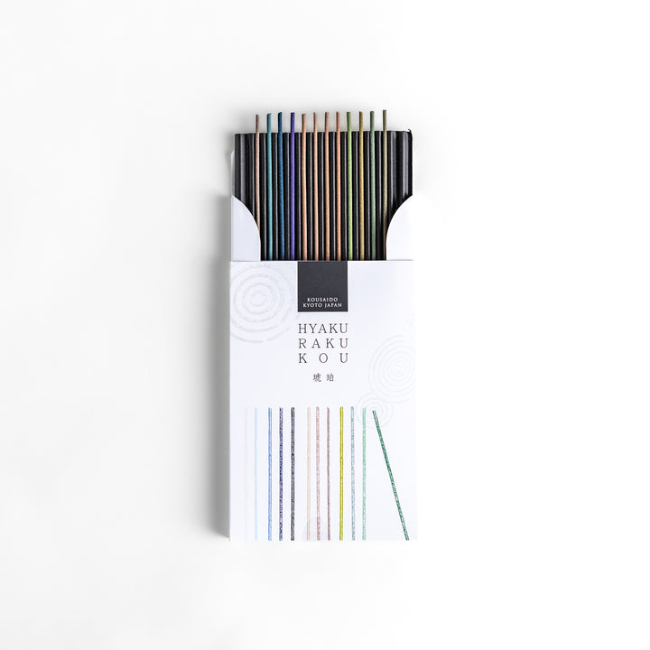 Incense set featuring a variety of colorful sticks elegantly packaged in a sleek white box with subtle circular patterns, offering a refined selection of rich and soothing aromas.