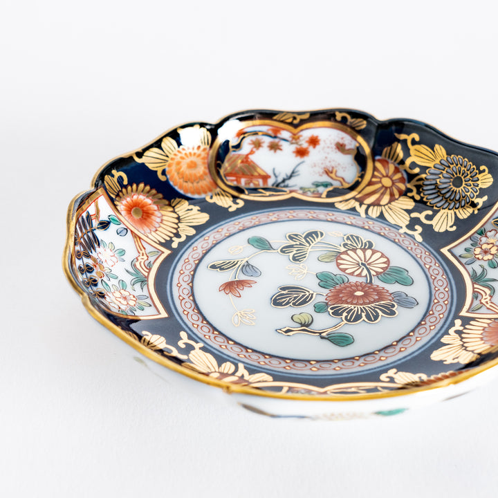 Close-up of the floral design on the Imperial Blossom sauce dish, with intricate flowers in red, gold, and green, set against a white and blue background.