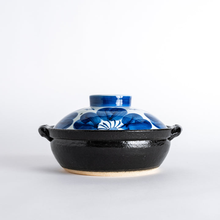 A 8-inch donabe with a vibrant blue floral pattern lid and black pot.