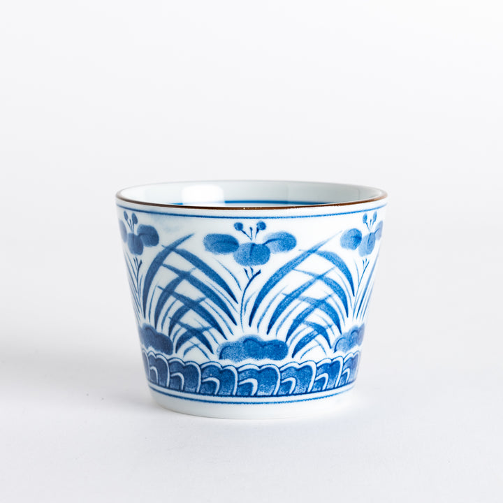 Side view of a ceramic bowl featuring a blue and white pattern with delicate floral and leaf motifs reminiscent of iris flowers, showcasing a refined design.