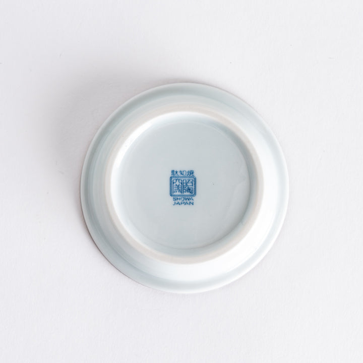 The underside of the dish, showing the smooth base and a blue marking that indicates its origin or brand.