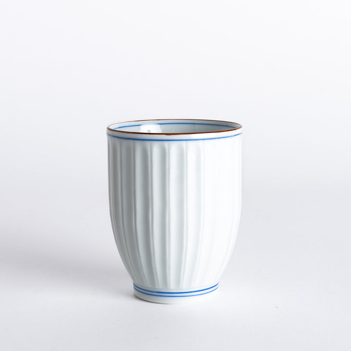 Side view of the Ivory Fluted Tea Cup, emphasizing the vertical grooves and the refined blue and brown rim details.