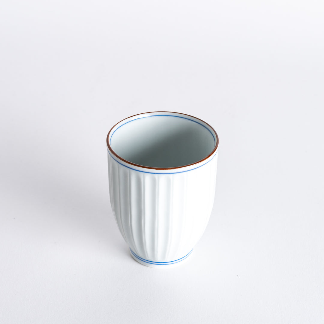 Slightly angled view of the Ivory Fluted Tea Cup, highlighting the elegant vertical grooves and delicate blue accents.