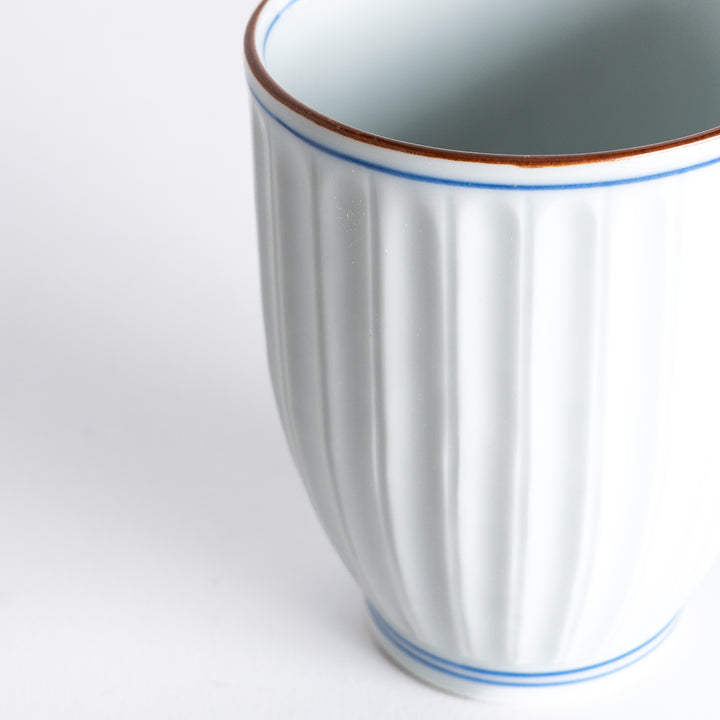 Close-up of the Ivory Fluted Tea Cup, focusing on the intricate fluted texture and fine blue and brown rim details.