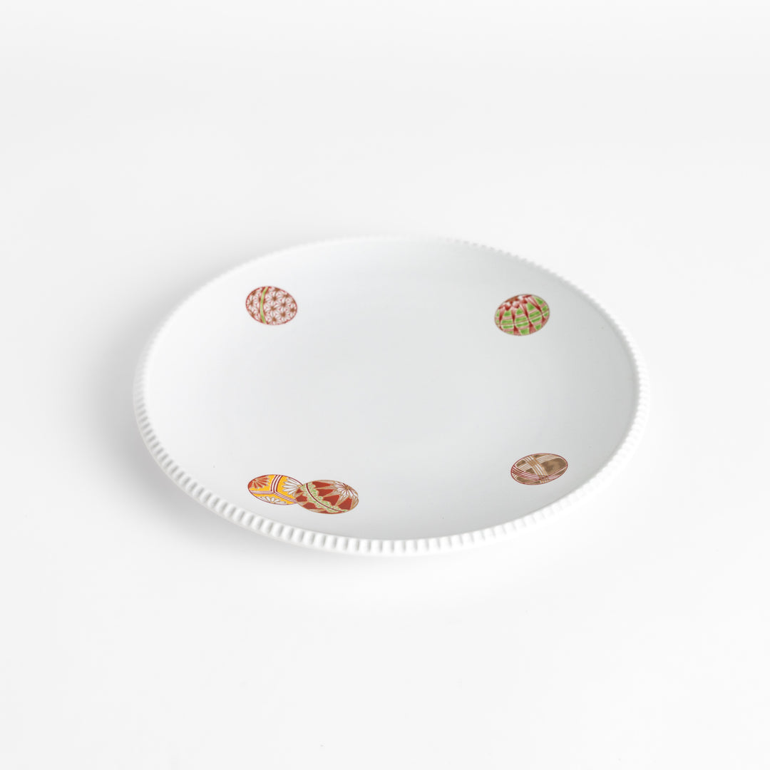 White dinner plate with vibrant temari ball designs, showcasing intricate details.