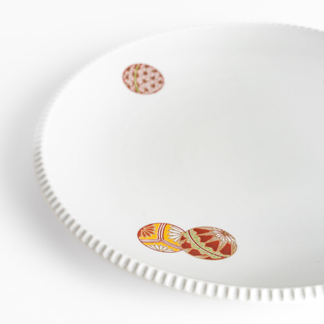 White dinner plate with vibrant temari ball designs, showcasing intricate details.