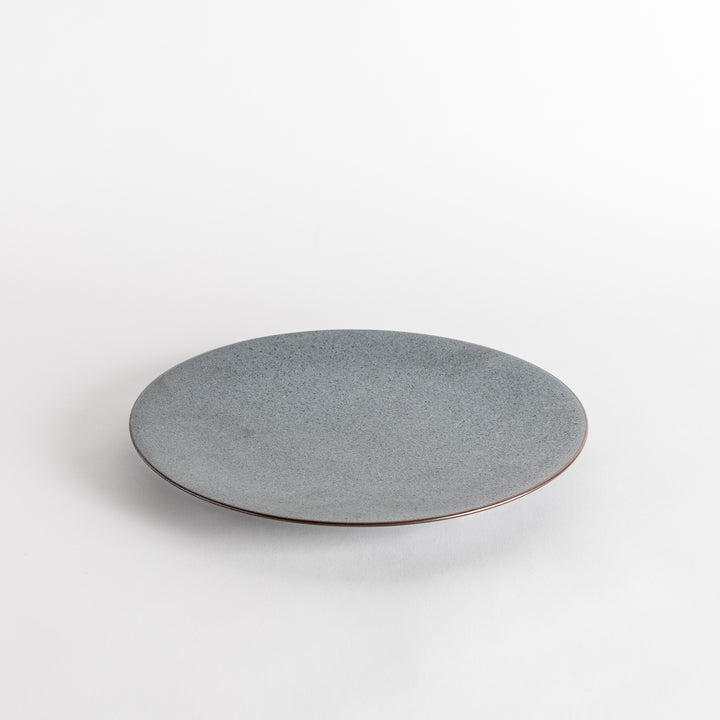 A round, matte black dinner plate with a smooth, understated design.