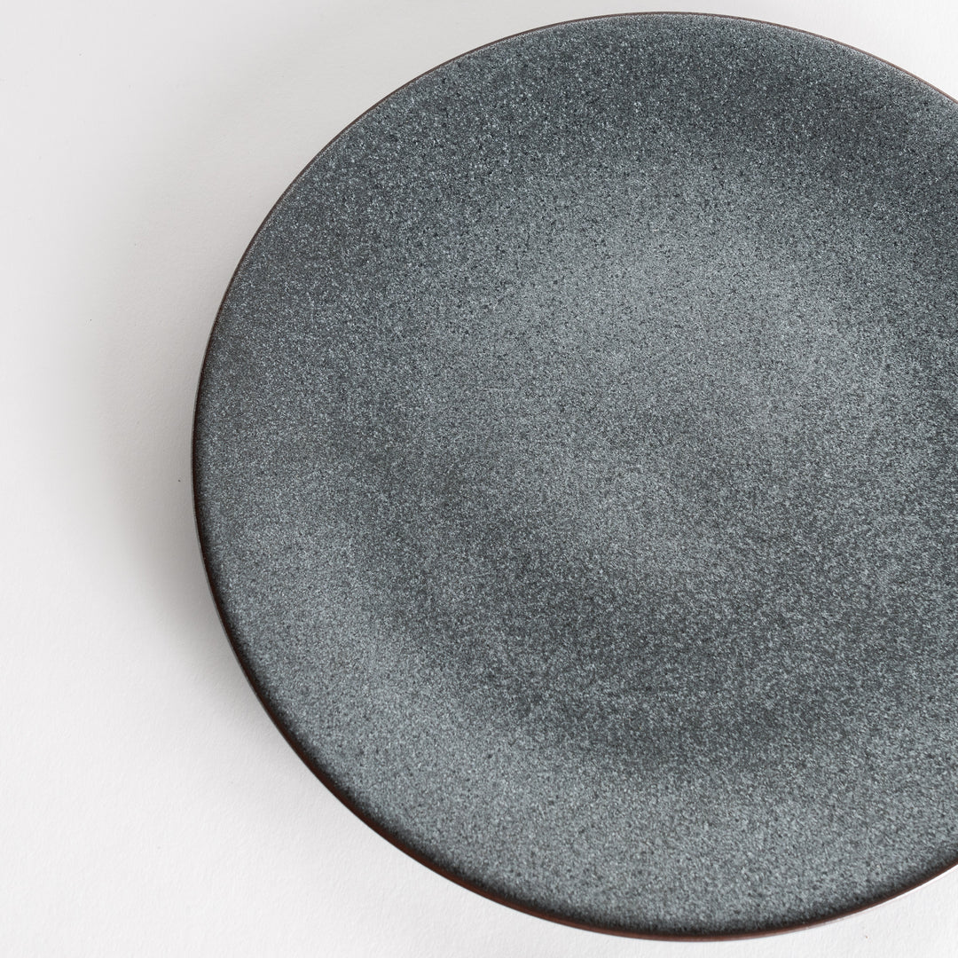 A round, matte black dinner plate with a smooth, understated design.