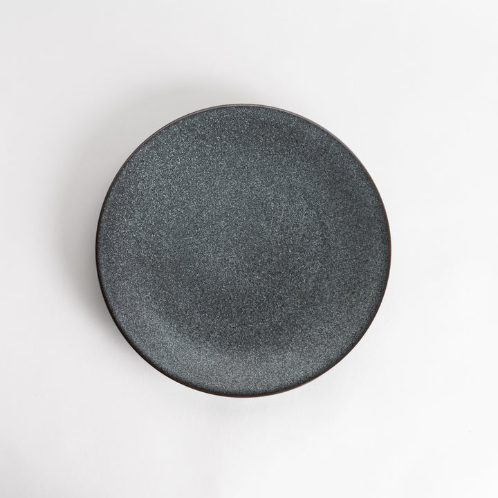 A round, matte black dinner plate with a smooth, understated design.