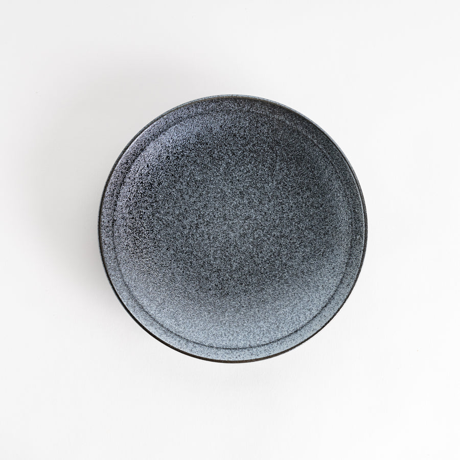 A round black salad plate with a subtle, rustic texture, ideal for modern table settings.