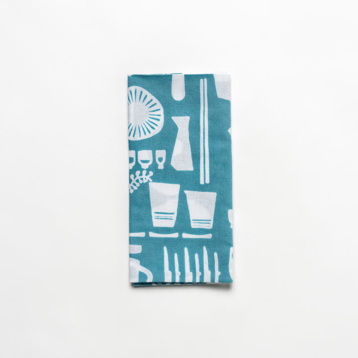 Blue Tenugui Hand Towel with a white graphic print of various kitchen utensils and tableware.