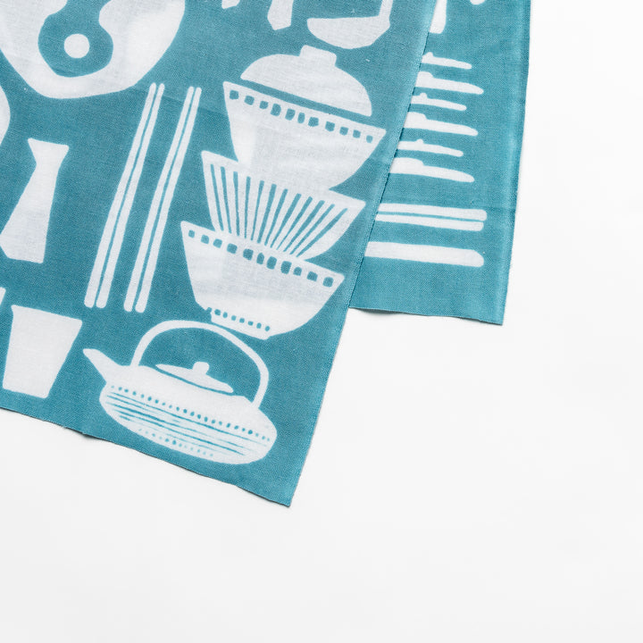 Blue Tenugui Hand Towel with a white graphic print of various kitchen utensils and tableware.