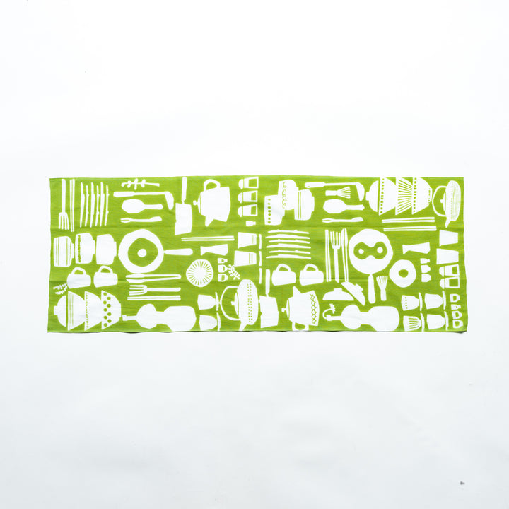 Green tenugui hand towel fully spread, featuring white kitchenware patterns such as bowls, whisks, spoons, and teapots in a seamless layout.